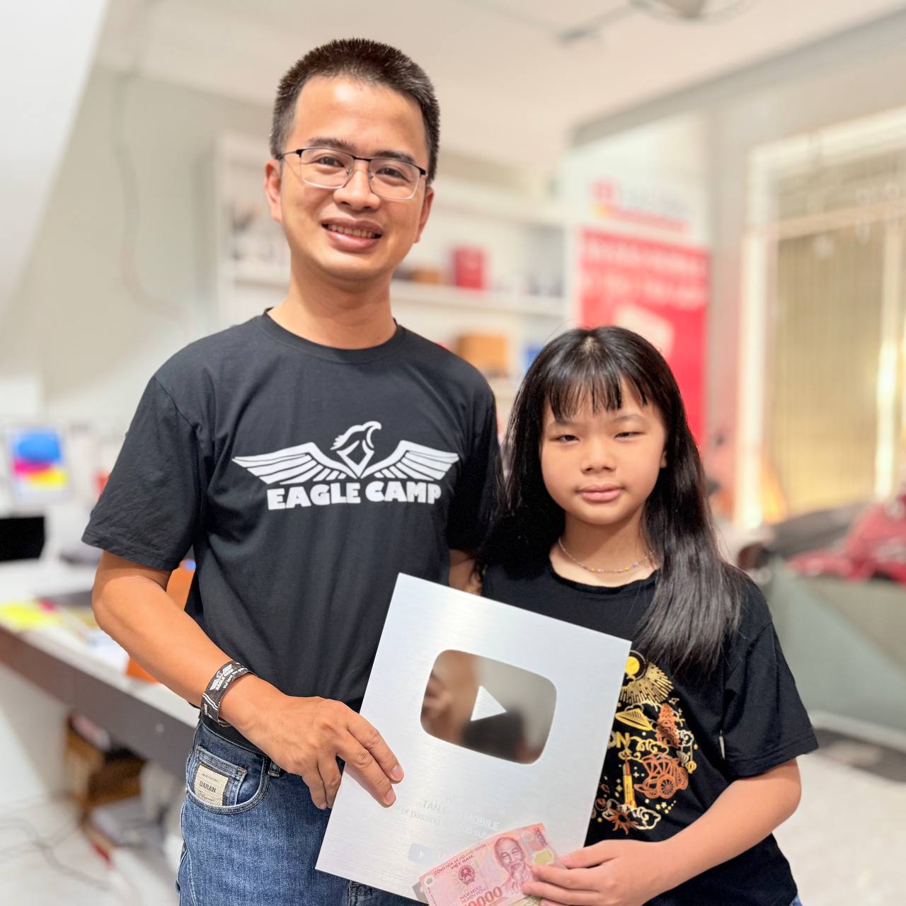 Hai vợ chồng Chung và Lê Tấn Đào cùng cầm Nút Bạc YouTube của kênh Tấn Đào Mobile