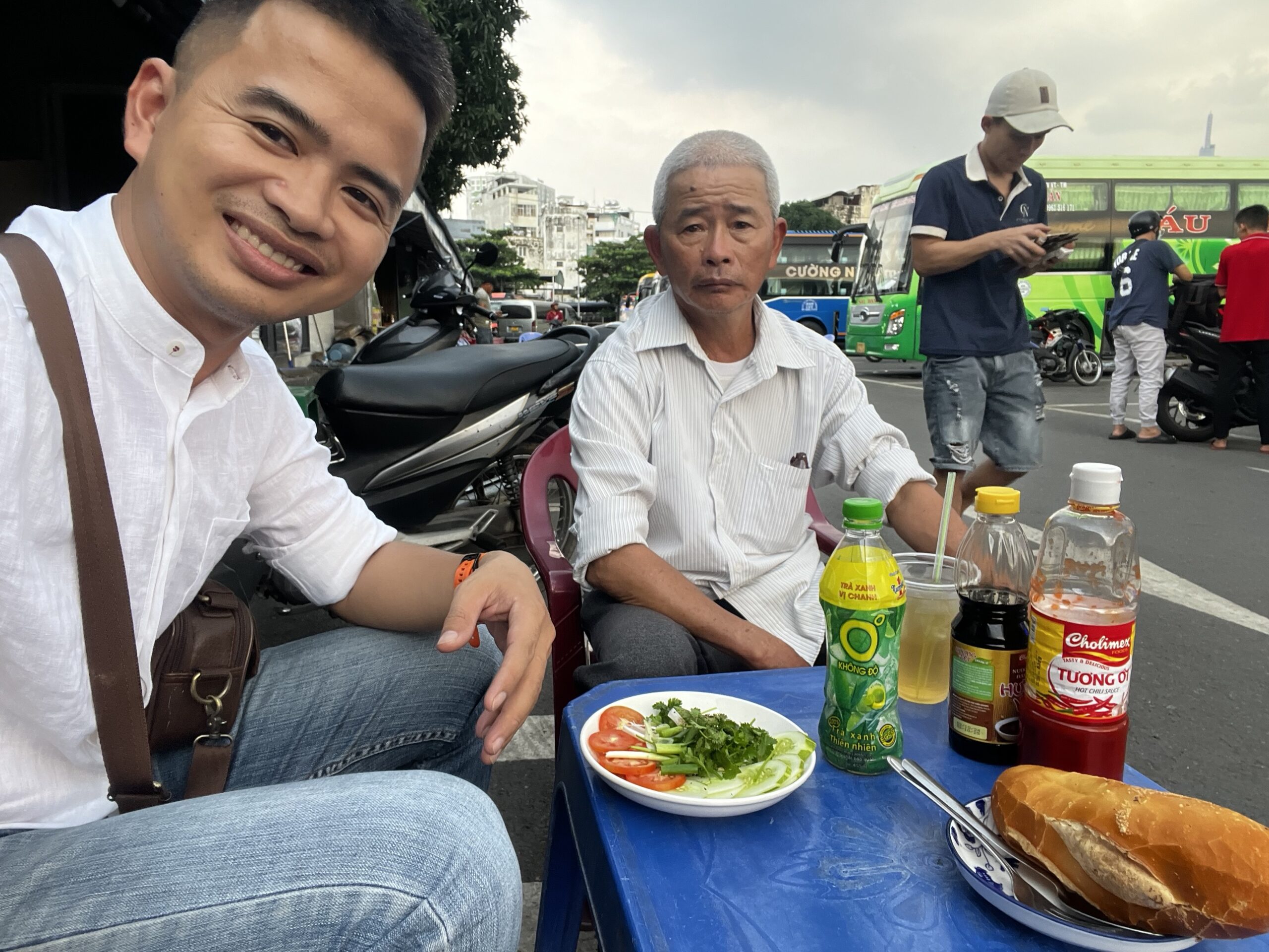 Hai cha con ngồi ăn ở quán vỉa hè gần bến xe, bữa tiễn ba về quê
