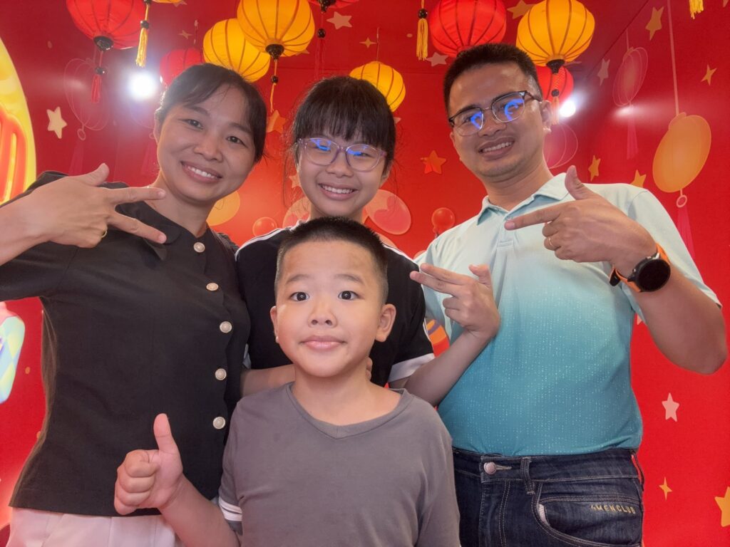 Tony cùng gia đình Lê Tấn Đào chụp ảnh trước phông đèn lồng Trung Thu